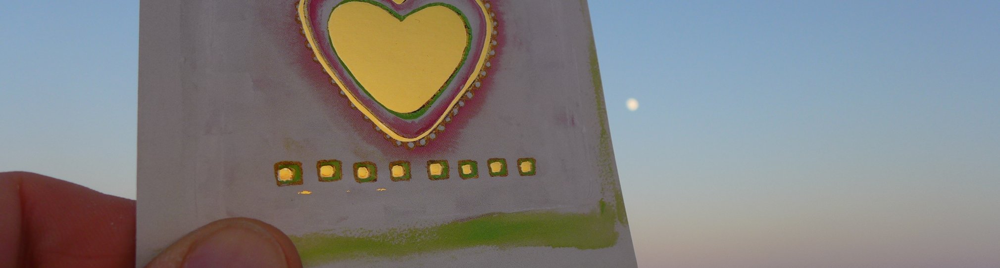 Karte gehalten vor dem Himmel mit Herz.Freude am leben