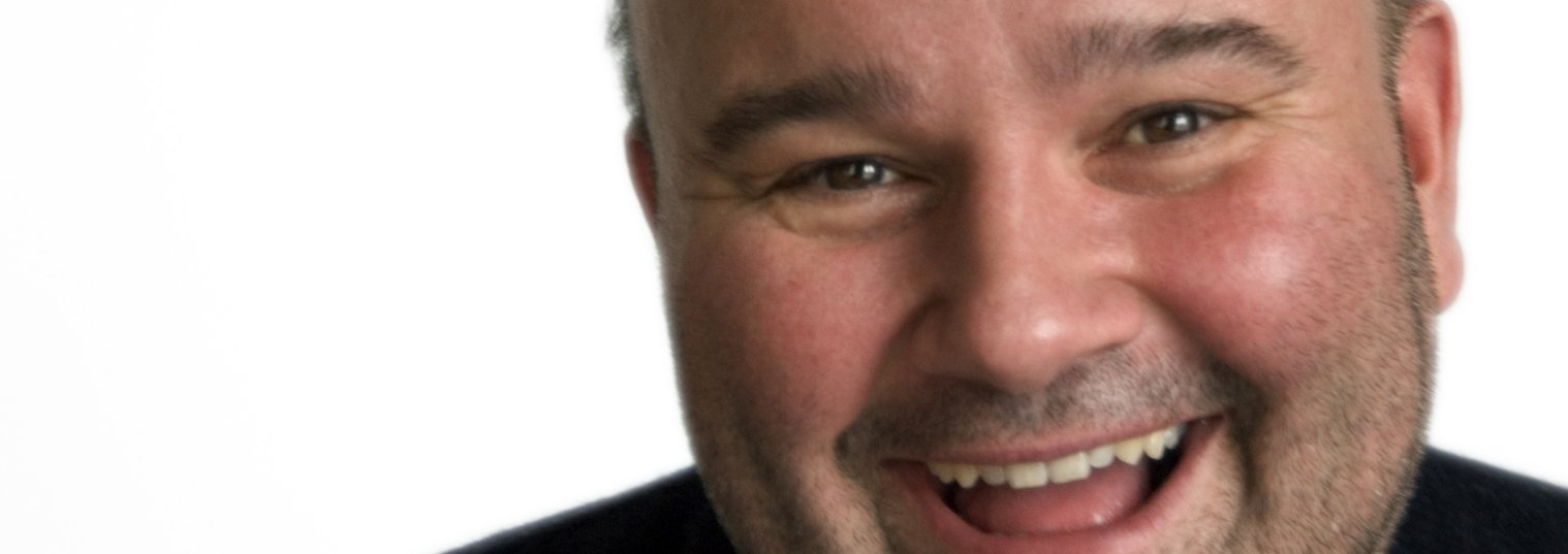 Foto Lachender sympatischer molliger Mann als Führungskraft.