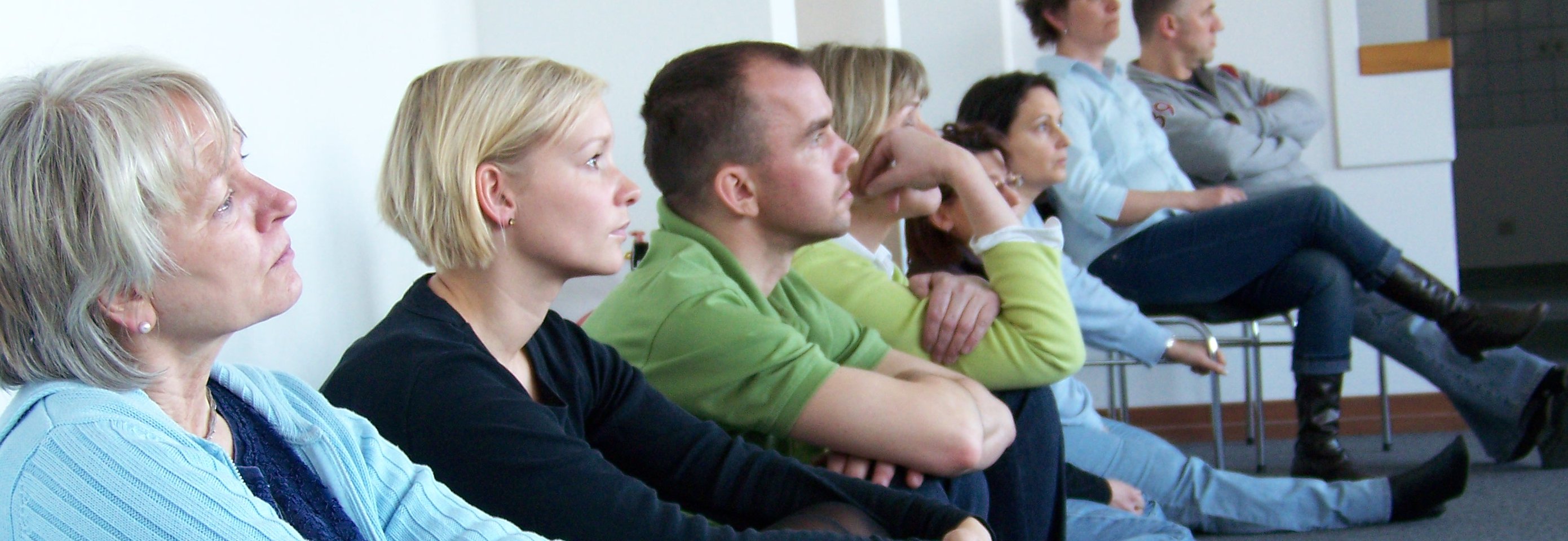 Teamgruppe schaut und lauscht gebannt dem Vortrag von Ralf Käppler Stepout Foto