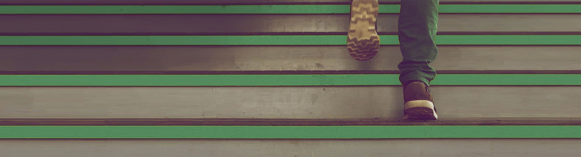 Titelbild Füsse die ein treppe nach oben zum Erfolg steigen.